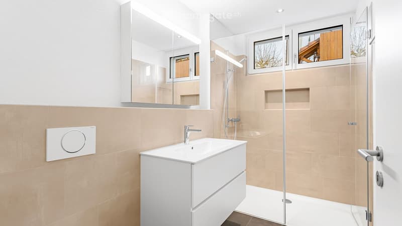 Bathroom. Modern bathroom with a white sink, mirror cabinet, glass shower enclosure, and beige tiles.