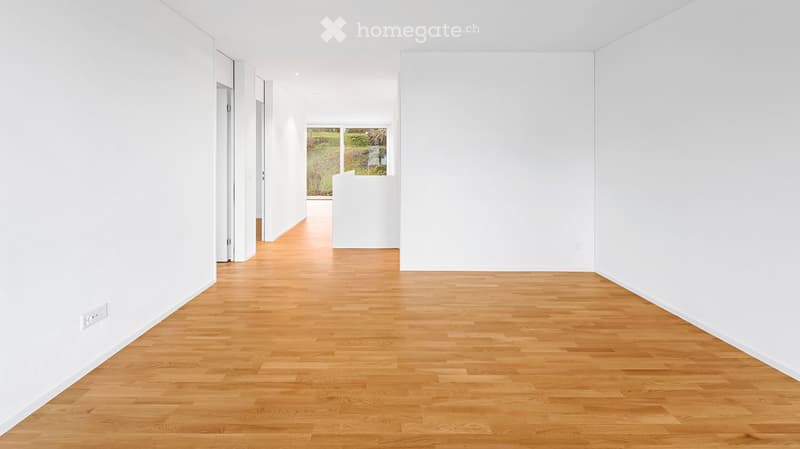 Unfurnished Room. Empty hallway with light wooden flooring and white walls, featuring a large window at the end that lets in natural light.