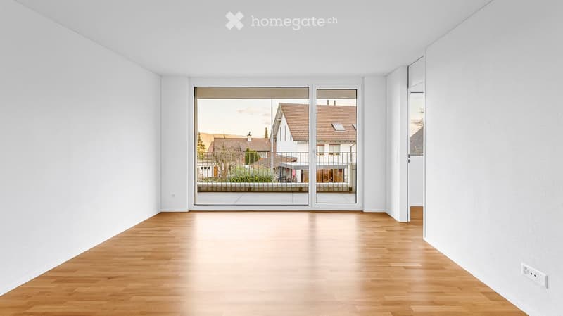 Unfurnished Room. Empty room with light wooden flooring and white walls, featuring large glass doors leading to an outdoor area.