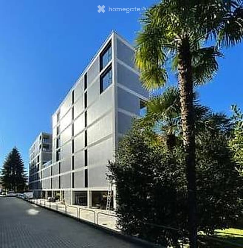 Modern multi-story building with a sleek, contemporary design, featuring large windows and a clean, minimalist facade.