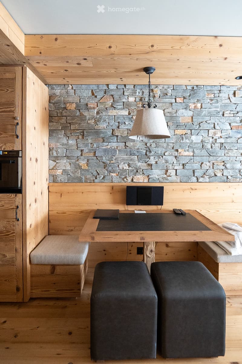 wooden wall, stone wall, black desk, black ottomans, wooden floor