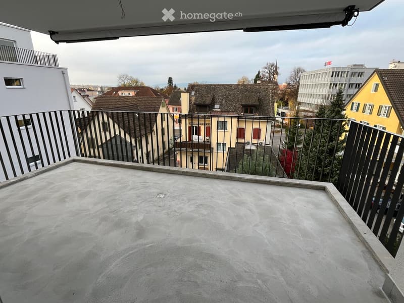 concrete floor balcony with metal railings, concrete wall, cityscape view