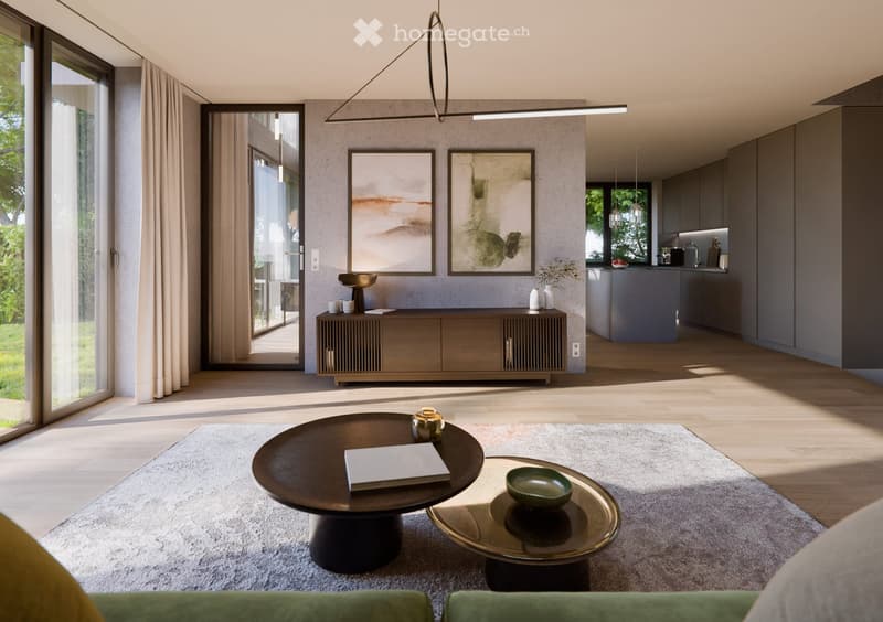Modern living room with a grey sofa, dark wooden coffee table, side table, and a sleek cabinet. The space features large windows with curtains, a modern pendant light, and a view of a kitchen area with grey cabinets and a counter.