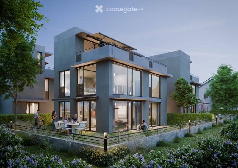 Modern two-story residential building with large glass windows, balconies, and a raised ground floor. The building features contemporary design with clean lines and a neutral color palette.
