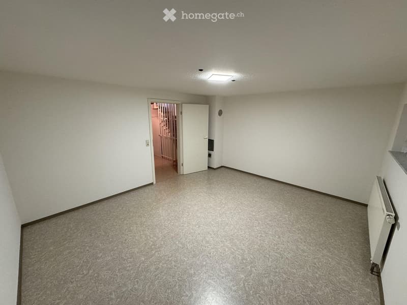 Empty room with carpeted floor, white walls, and a single door leading to another space. No furniture or equipment present.