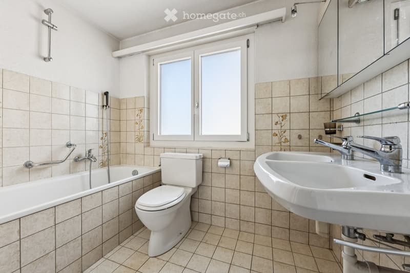 Bathroom with bathtub, toilet, sink, and window