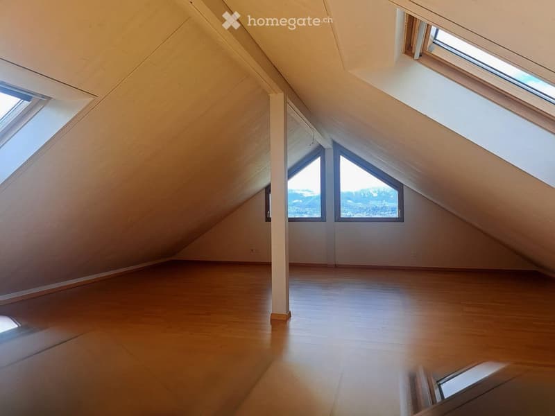 empty attic room, wooden floor, slanted ceiling, three windows