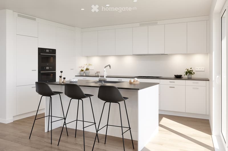 Modern kitchen with white cabinets, black countertop, island with bar stools, sink, oven, and small decorative items.