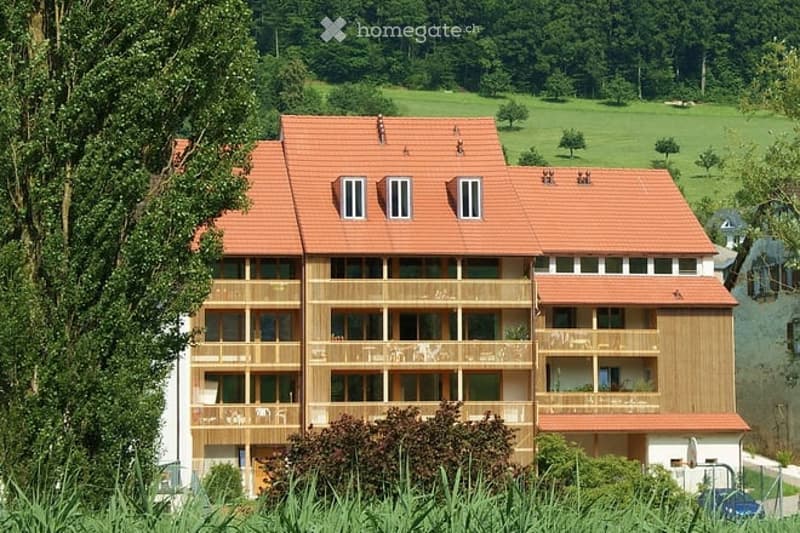 multi story building, red roof, wooden balconies, garden view