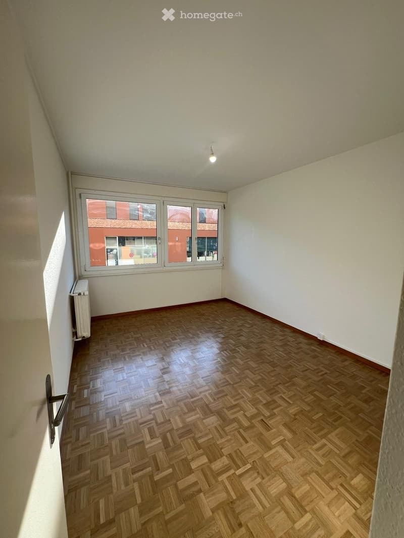 empty room, wooden parquet floor, white walls, large windows, white radiator, ceiling light