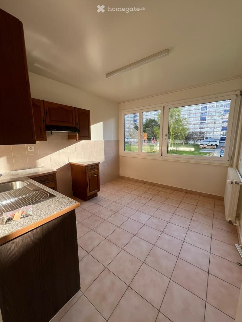 kitchen with tiled floor, wooden cabinets, sink, windows, large windows with view
