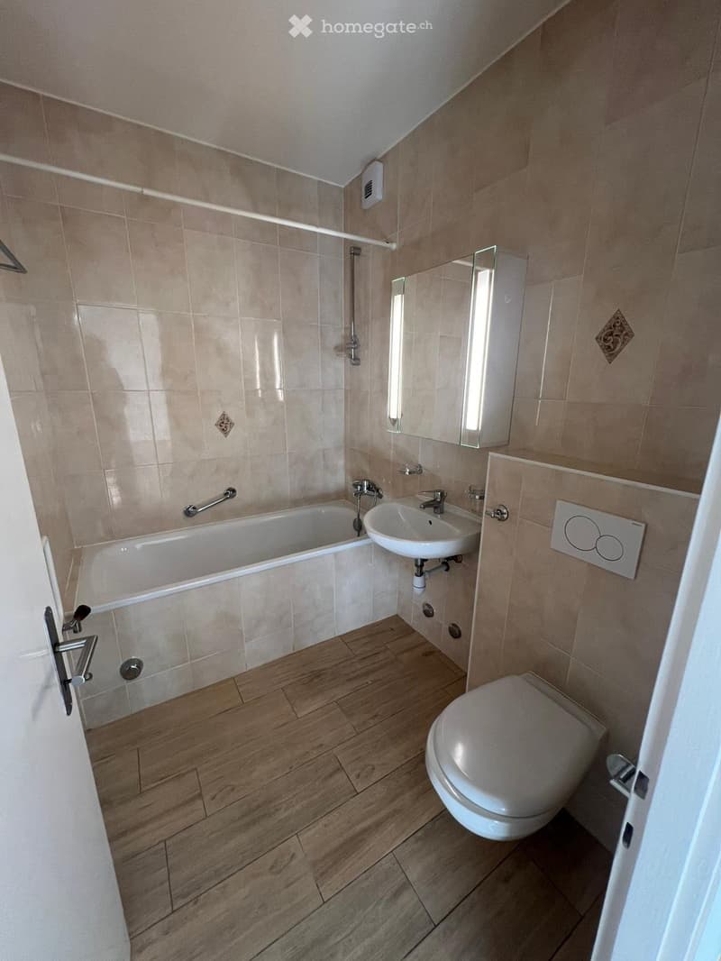 Bathroom with bathtub, sink, toilet, and mirror