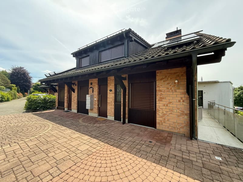 Two-story house with brick facade, garage, and curved brick driveway.
