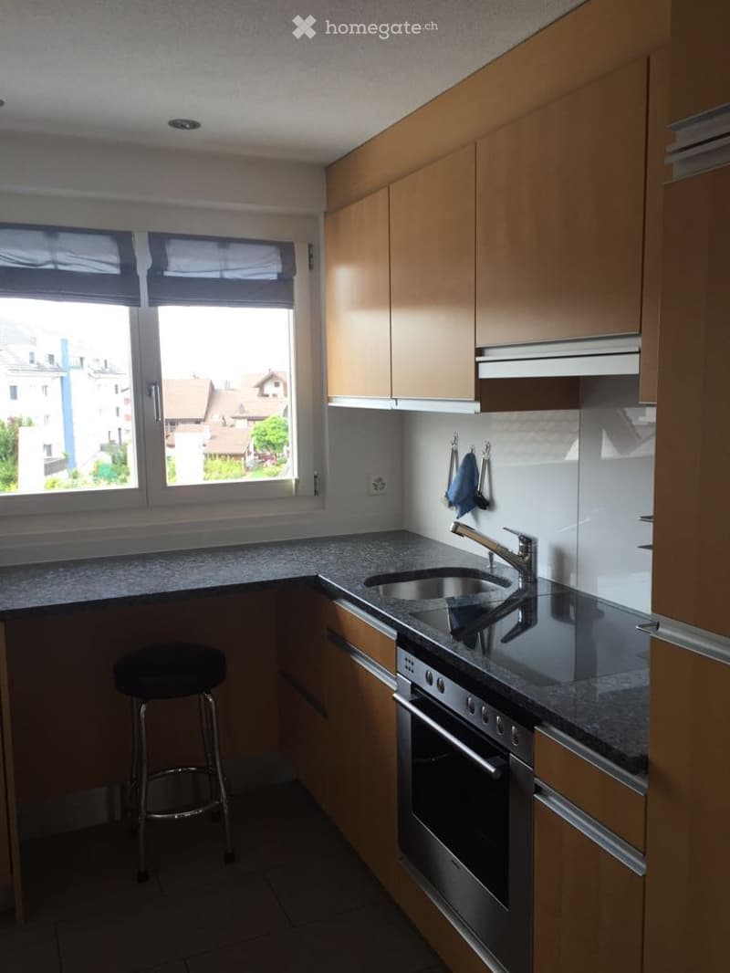 modern kitchen with granite counter, sink, oven and gas stove, and a window overlooking a scenic view