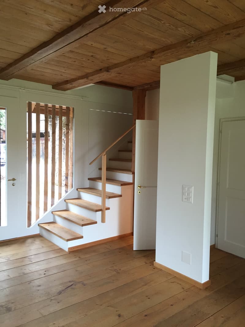 Empty room with wooden stairs, white walls, wooden floors, wooden ceiling