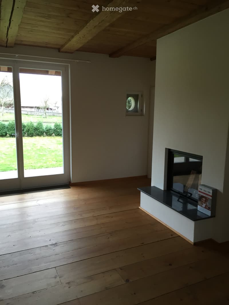 wooden floor, white walls, fireplace, sliding glass door