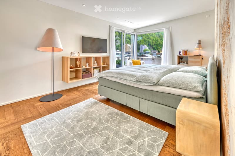 wooden floor, double bed, large glass windows, sliding doors to balcony, wall-mounted TV, nightstand, lamps, wooden cabinet with shelves