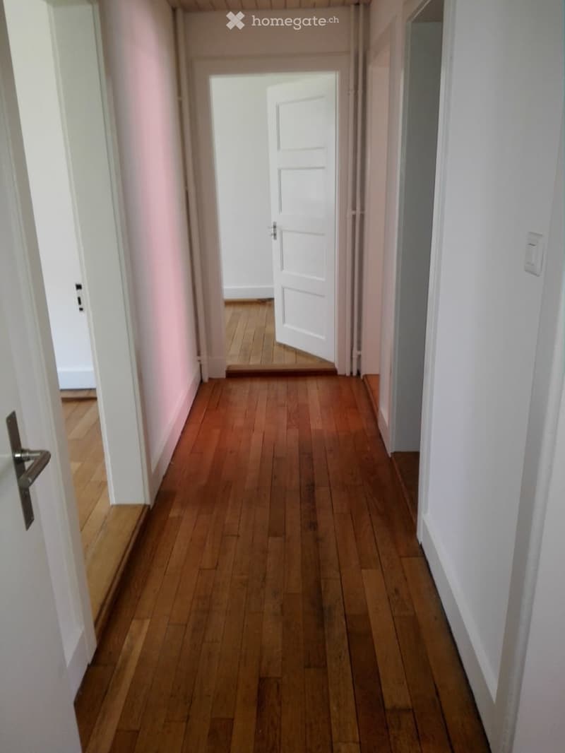 hallway, wooden floor, white walls, open door