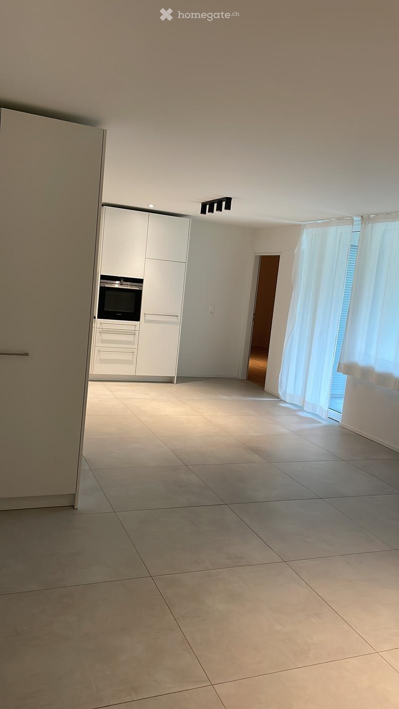 Empty room with tiled floor, white cabinetry, and a window with curtains. No furniture or equipment present.