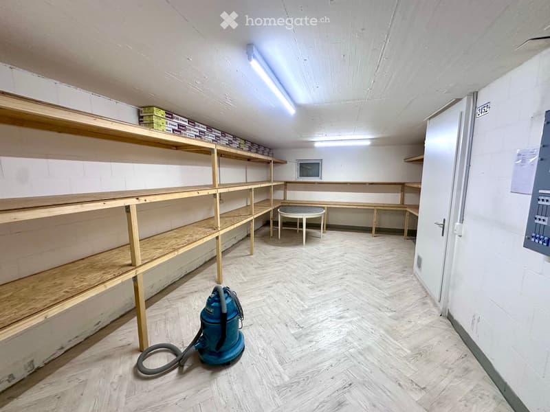 Empty storage room with wooden shelves, white tiled floor, circular table, fluorescent lights
