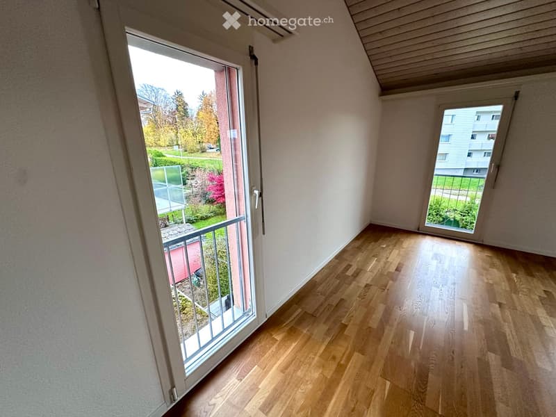 room with glass doors leading to balcony, wooden floor