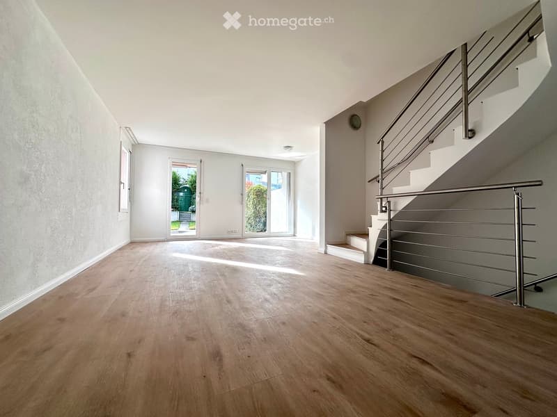 Empty room, wooden floors, white walls, glass doors, white railing, spiral staircase