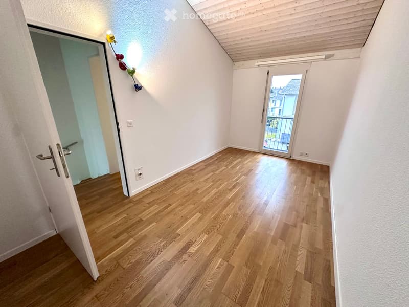 wooden floor, white walls, open door, glass door, balcony with railing, light fixture, electrical outlets