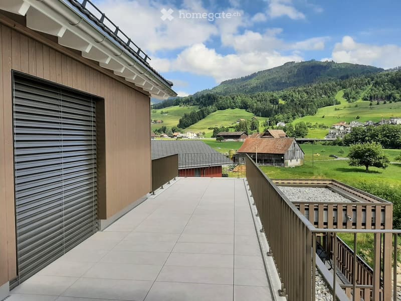Balcony with modern wooden railing, tiled floor, and scenic mountain view.