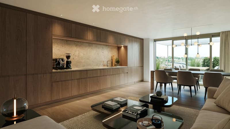 Modern, open-concept living and dining area with a kitchen island, featuring a sofa, coffee table, dining table, and chairs. The space includes a coffee machine on the island and a view of a balcony.