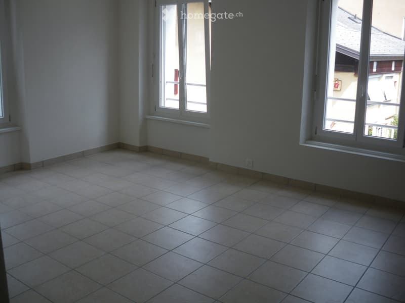 Empty room with tiled floor and large windows, no furniture or equipment.