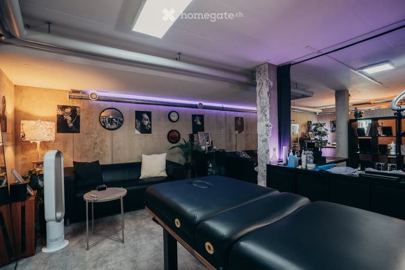 black leather couches, decorative items on wall, lamps, table, black leather chairs