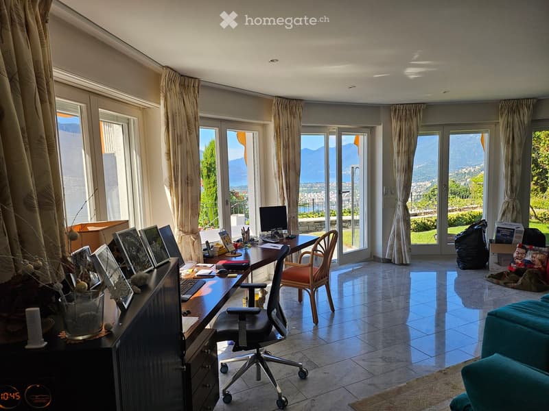 Open layout with large windows, desk with computer and chair, modern decor