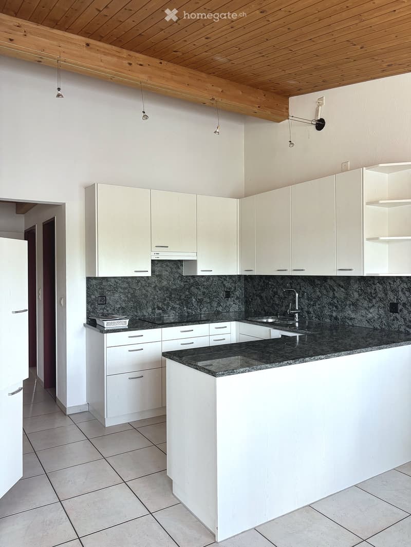 Modern kitchen with white cabinets, granite countertop, and stainless steel sink.