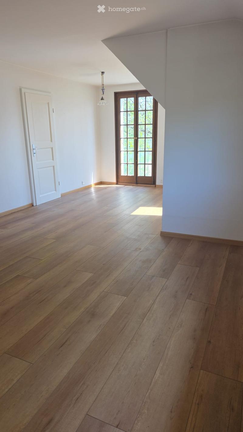 Empty room with wooden flooring, white walls, and a large window with glass panels. No furniture or equipment is present.
