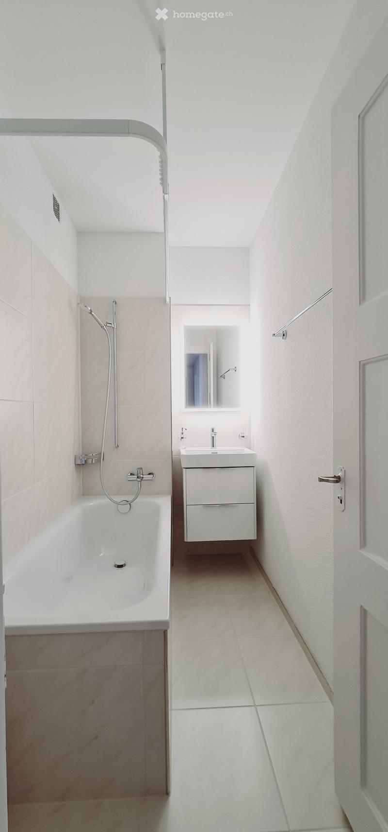 Bathroom with bathtub, sink, mirror, and shower head