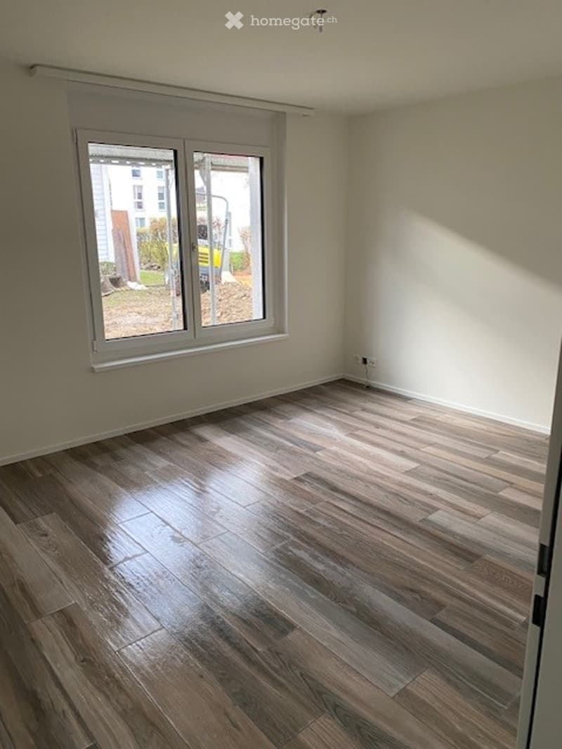 empty room, wooden floor, white walls, large window, power outlets