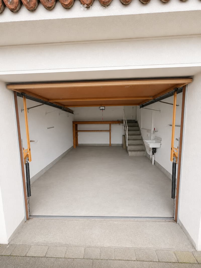 {"type": "Garage", "objects": [], "description": "Garage with concrete floor, wooden ceiling, small staircase leading to a sink area, and a workbench.", "localized_descriptions": {"EN": "Garage with concrete floor, wooden ceiling, small staircase leading