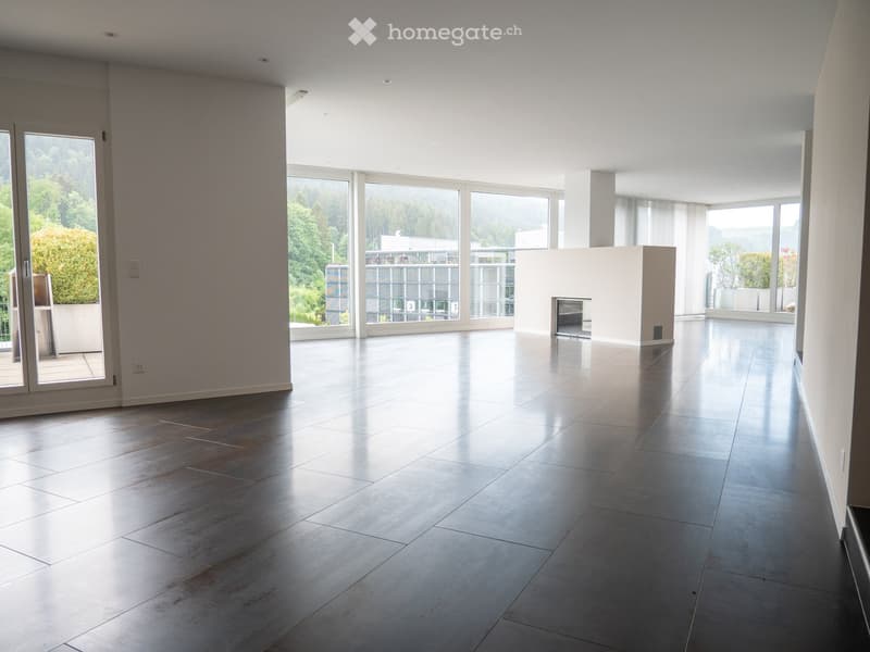 Empty room with large windows, polished tile floor, and a fireplace. No furniture or equipment present.