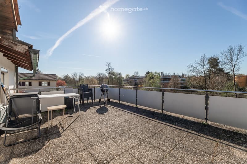 Balcony with gravel flooring, metal railing, and outdoor furniture including chairs, a table, a stool, and a grill.