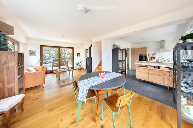 Open plan living room and kitchen, wooden floor, large windows, dining table, couch, kitchen island, wooden cabinets, modern appliances
