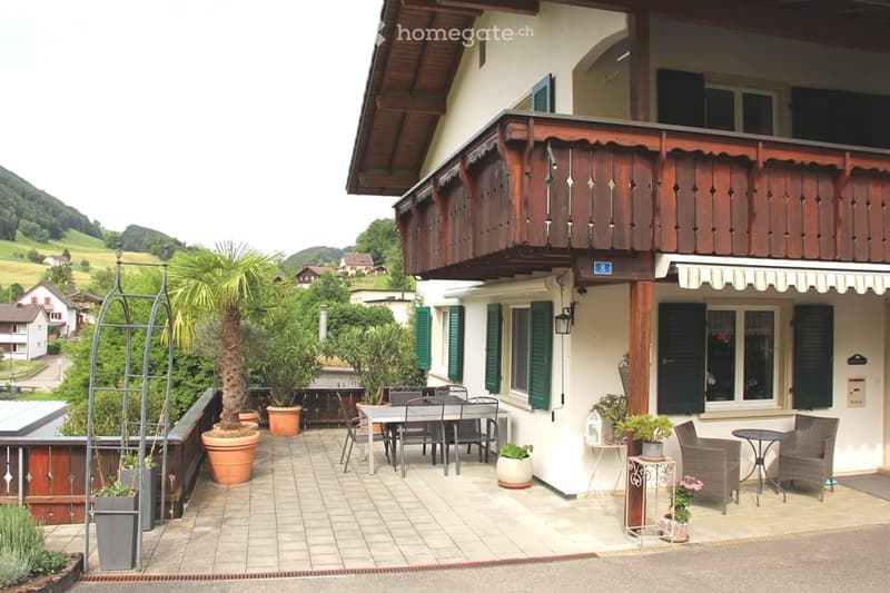 Balcony area with outdoor furniture, potted plants, and scenic countryside view.
