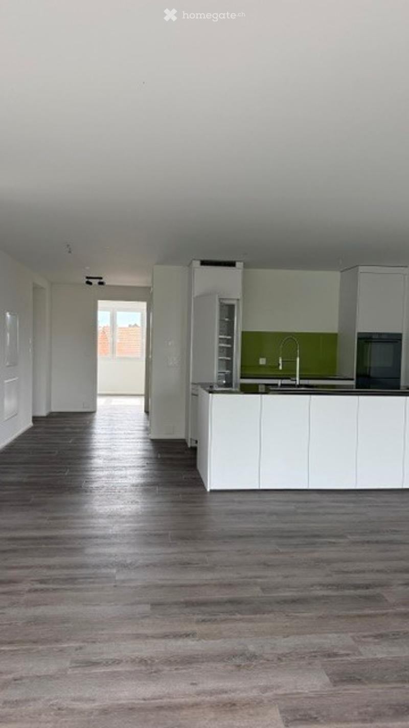 Unfurnished Room. Empty kitchen with white cabinets, green backsplash, and wooden flooring. No furniture or appliances visible.