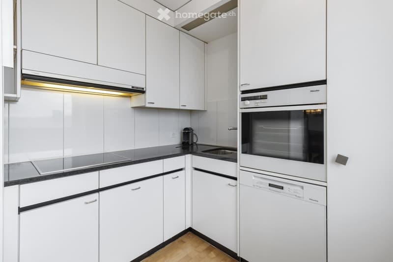 Kitchen. Modern kitchen with white cabinets, black countertops, and stainless steel appliances.