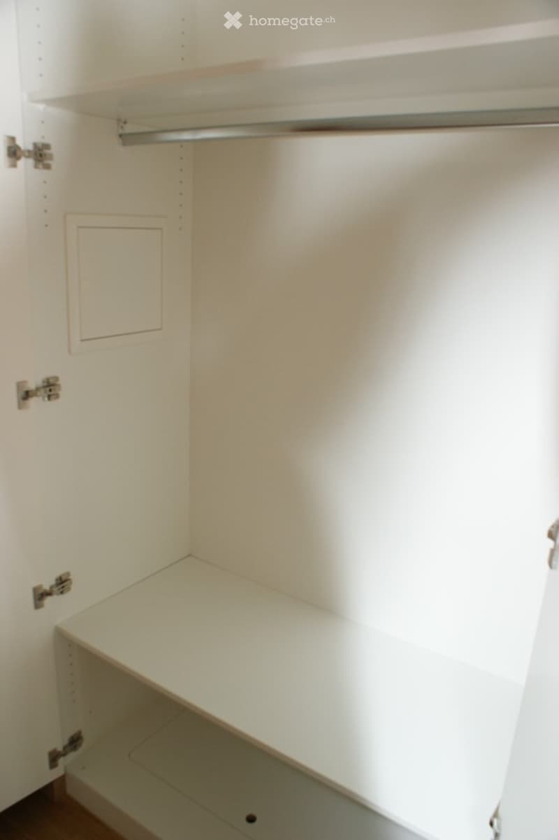 Empty closet with white walls, a single shelf, and a hanging rod. No furniture or items present.