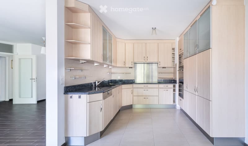 Kitchen. Modern kitchen with light wood cabinets, stainless steel appliances, granite countertops, and a tiled floor.