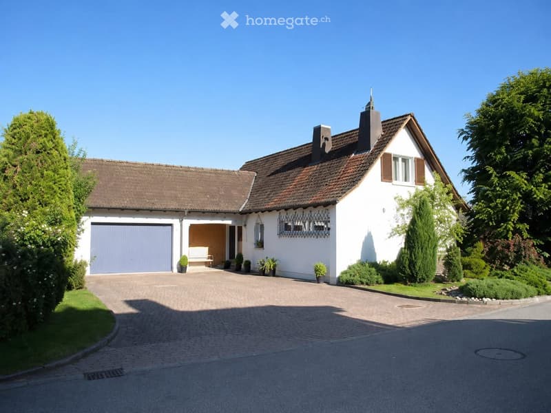 Two-story white house with a brown tiled roof, garage, and well-maintained garden.