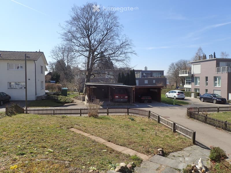 Residential area with multiple houses, a detached garage, and a fenced yard.