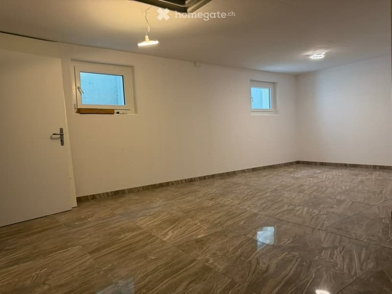 Empty room with wooden flooring, white walls, and two windows. No furniture or equipment present.