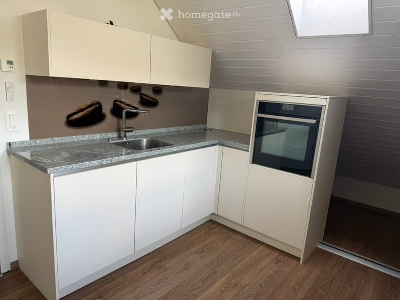 Modern kitchen with white cabinets, granite countertop, stainless steel sink and faucet, and built-in oven.