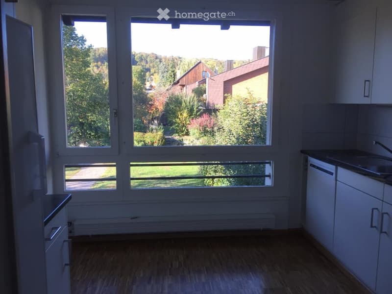 A small kitchen with a window view to a garden